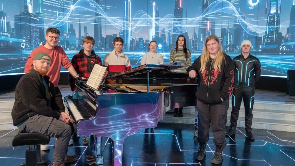 A group of eight music students from the BA (Hons) Music program at SETU are pictured in a futuristic, neon-lit "futureville" setting. They are gathered around a piano, which glows with digital accents, against a backdrop of towering, illuminated cityscapes and flowing data streams.